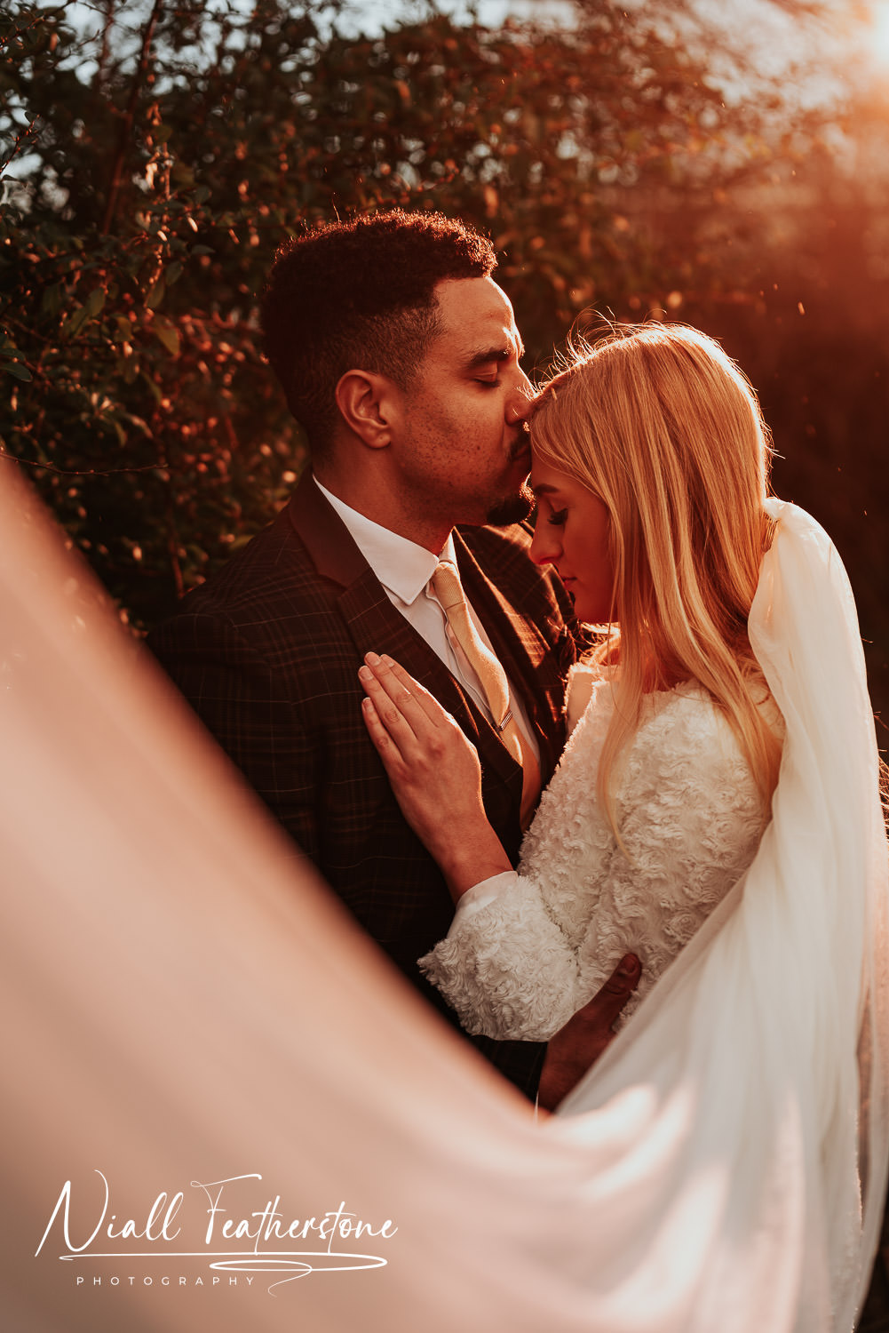 Bride and Groom embrace each other in the sunset